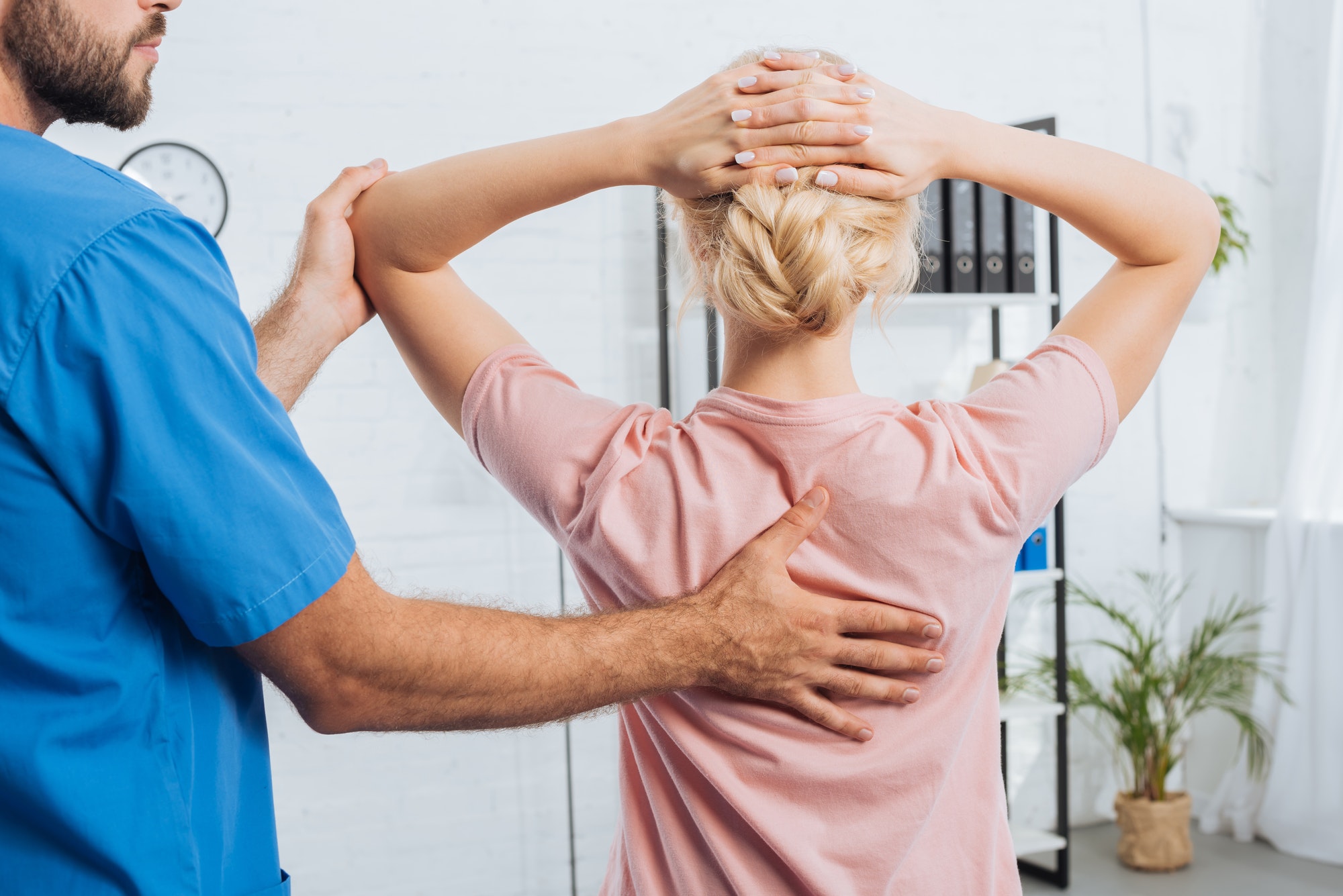 cropped shot of physiotherapist doing massage to woman on massage table in hospital