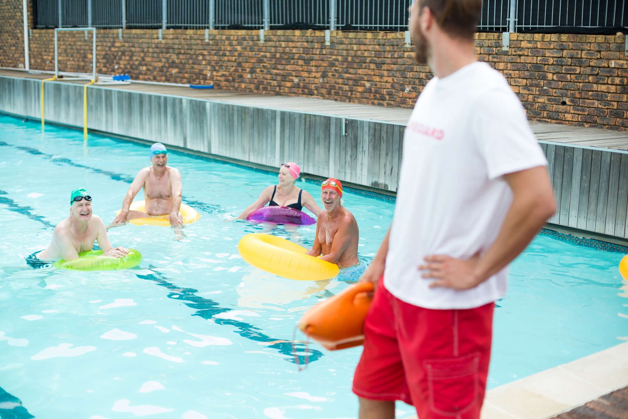 Lifeguard looking at swimmers swimming in pool